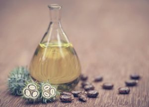 castor-oil-with-dry-and-green-beans-on-wooden-surface