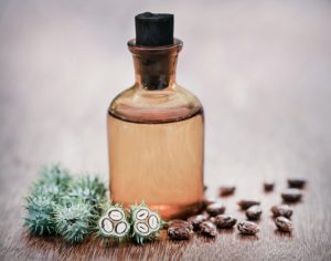 castor-oil-with-dry-and-green-beans-on-wooden-surface